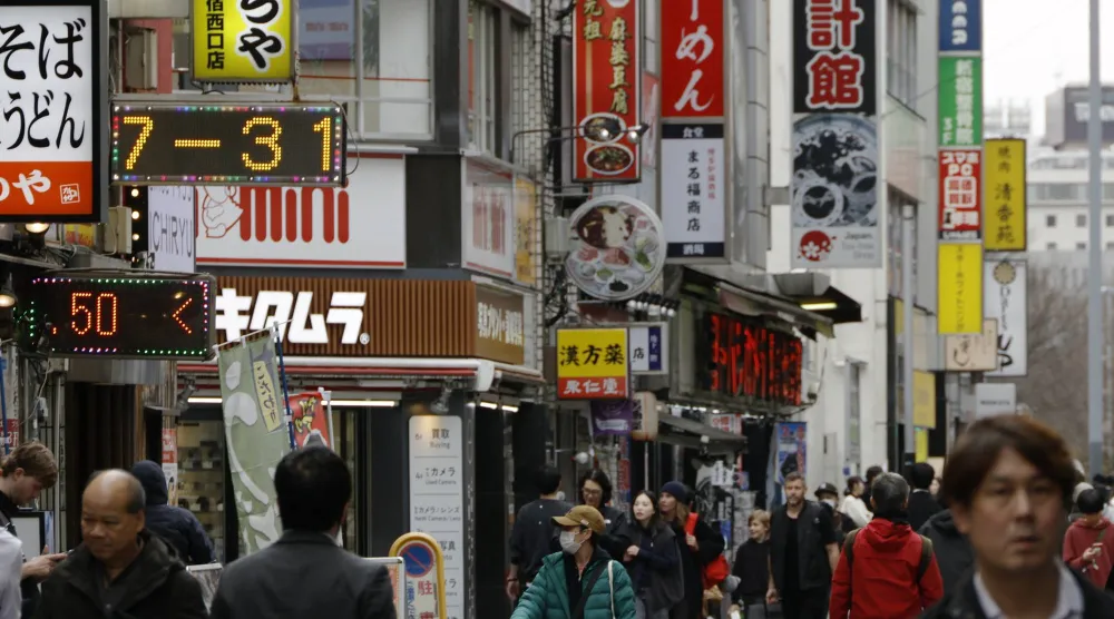 مشاة في إحدى الضواحي التجارية بالعاصمة اليابانية طوكيو (إ.ب.أ)