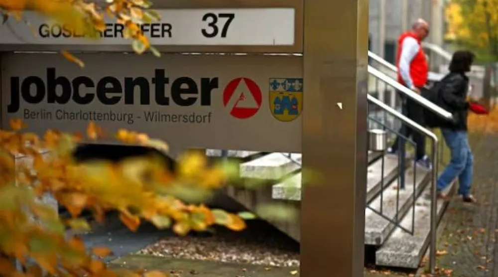 يمشي أشخاص خارج مركز توظيف في برلين (رويترز)
