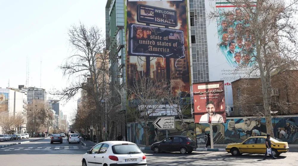 لوحة إعلانية معادية لإسرائيل والولايات المتحدة على مبنى في طهران (رويترز)