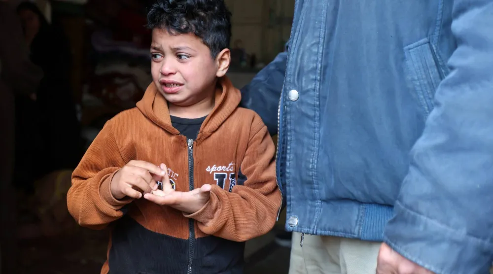 طفل فلسطيني خلال تشييع والده الشرطي الذي قُتل بغارة إسرائيلية في خان يونس الجمعة (رويترز)