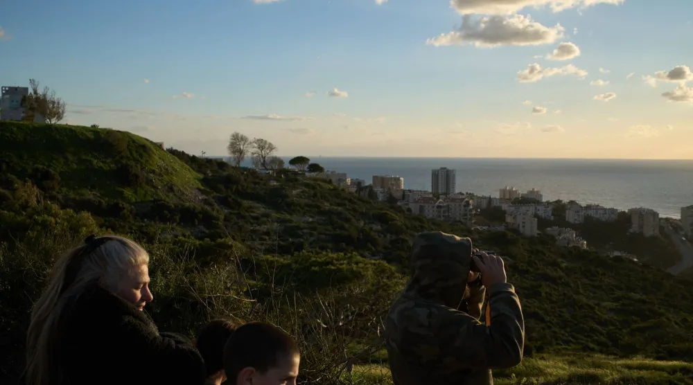 إسرائيليون يترقبون وصول حاملة الطائرات التابعة للبحرية الأميركية «جيرالد فورد» إلى ساحل حيفا (أ.ب)