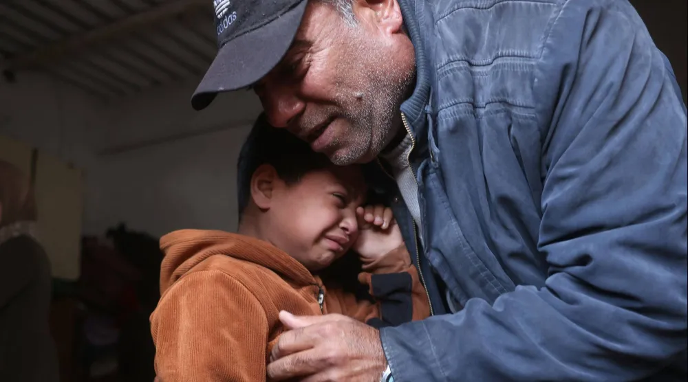 طفل فلسطيني يبكي أحد أقاربه الذي قُتل في غارات إسرائيلية على خان يونس جنوب قطاع غزة (أ.ف.ب)