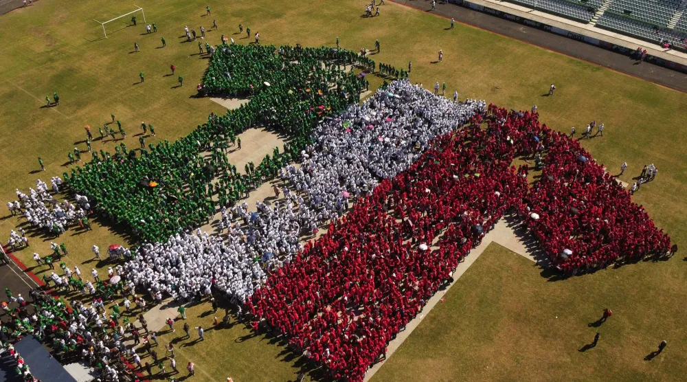 متطوعون يصطفون لتشكيل قميص المنتخب المكسيكي في ملعب فيكتور مانويل بمدينة توكستلا غوتيريز (رويترز)
