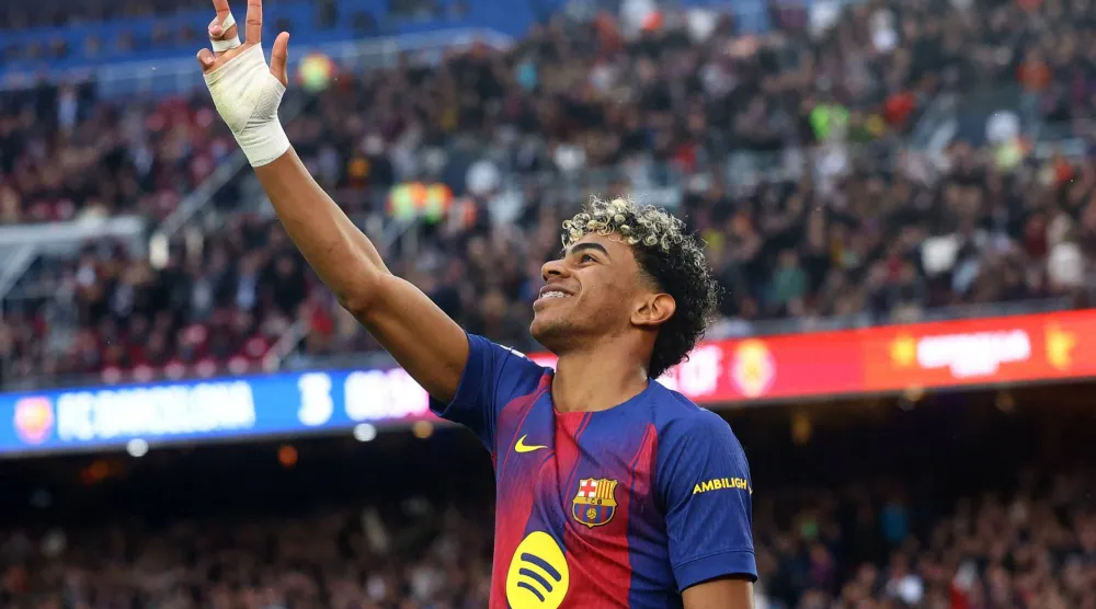 لامين جمال يشير بأصابعه الثلاثة احتفالاً بـ«الهاتريك» في مرمى فياريال (رويترز)