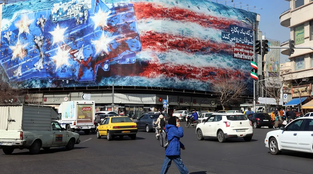 Iranians walk past an anti-US billboard at Enqelab Square in Tehran, Iran, 16 February 2026. (EPA) 