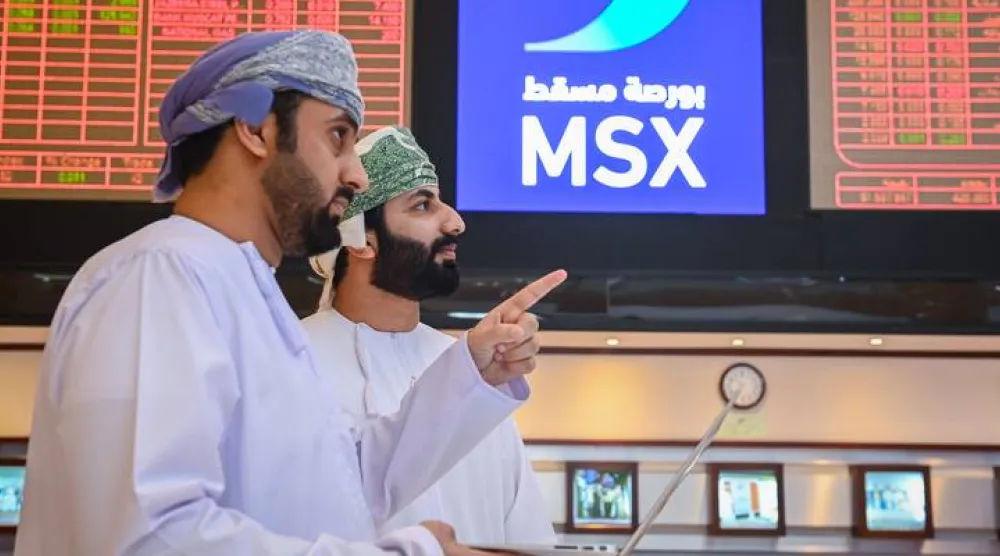 متعاملان يتابعان أسعار الأسهم في بورصة مسقط (وكالة الأنباء العمانية)