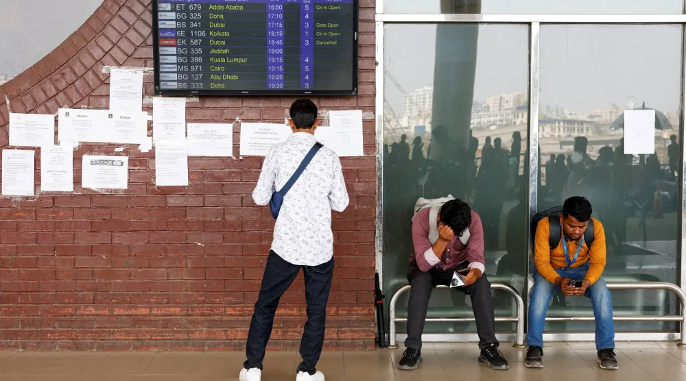 ركاب عالقون ينتظرون في مطار حضرة شاه جلال الدولي بعد إلغاء رحلات جوية إلى دبي والبحرين عقب غارات إيرانية (رويترز)