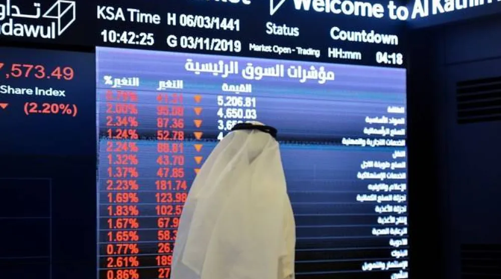 رجل ينظر لشاشة أسهم متراجعة في السوق السعودية (أ.ف.ب)