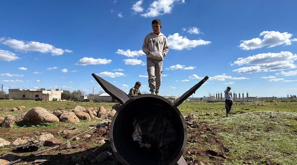 أطفال سوريون يلهون بحطام صاروخ إيراني اعترضته إسرائيل في ريف القنيطرة الجنوبي بالقرب من بلدة غدير البستان (أ.ف.ب)