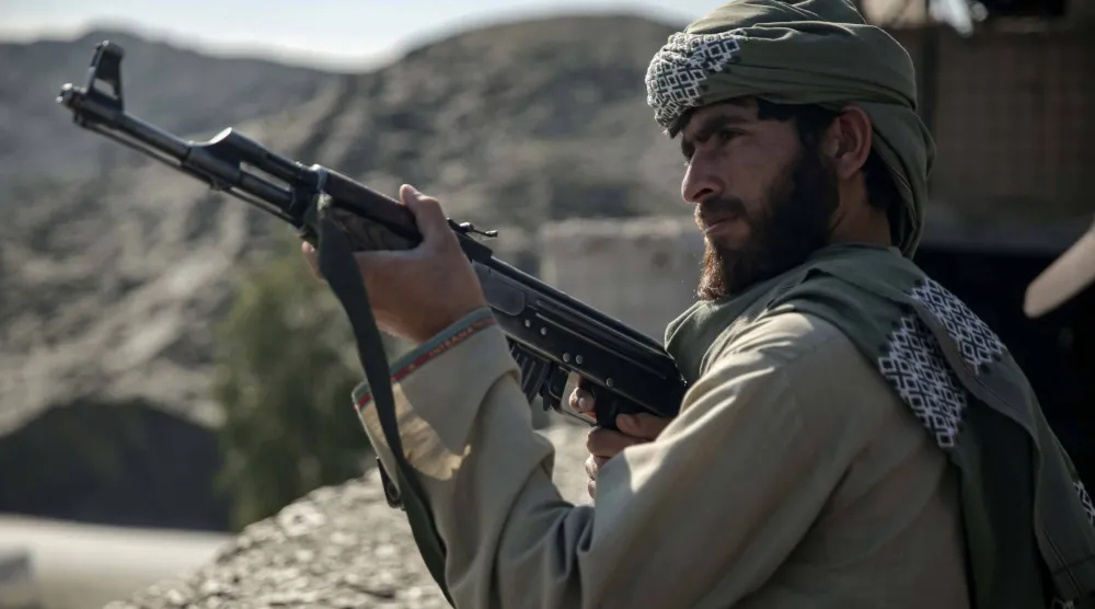 أحد عناصر حركة «طالبان» قرب معبر طورخم الحدودي الذي يعدّ ممرّاً أساسياً للأفغان العائدين من باكستان (إ.ب.أ)