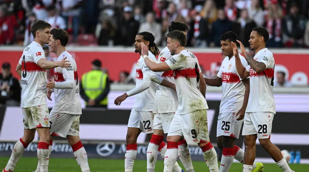 لاعبو شتوتغارت يحتفلون بالفوز على فولفسبورغ (أ.ف.ب)