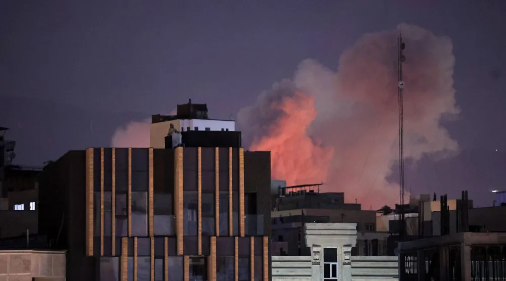 تصاعد الدخان خلف المباني بعد انفجار وقع في اليوم الثاني على التوالي من الضربات التي شنتها الولايات المتحدة وإسرائيل في طهران (إ.ب.أ)