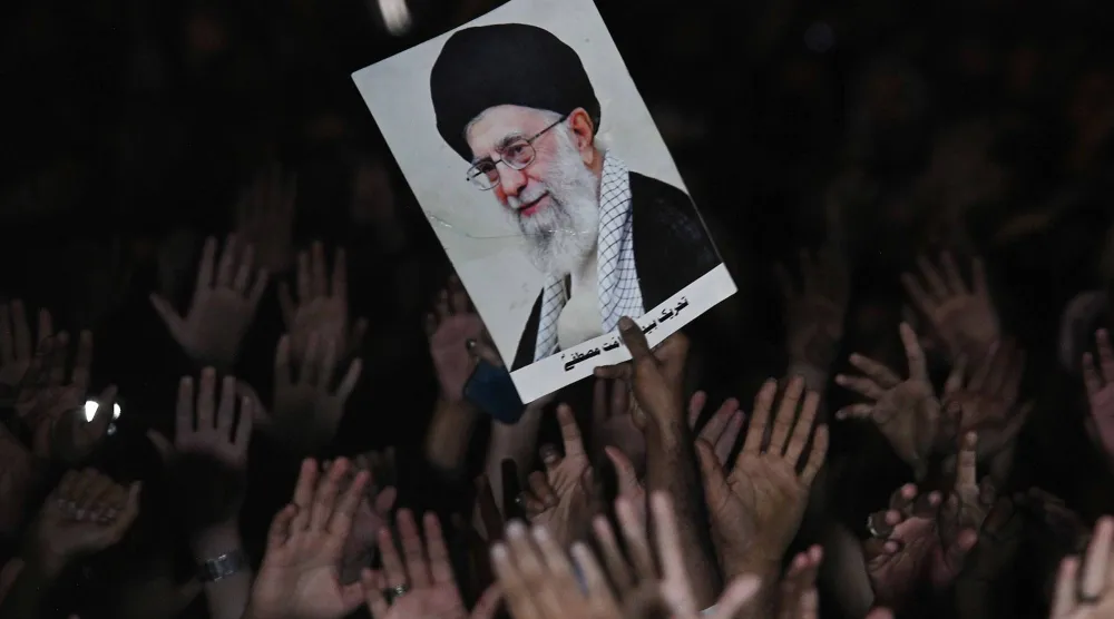 أنصار المرشد الإيراني يرفعون صورته خلال مسيرة حداد على مقتله (إ.ب.أ)