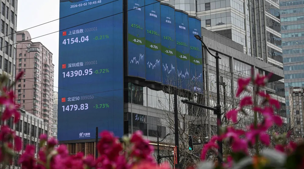 شاشة تعرض حركة الأسهم في الضاحية التجارية بمدينة شنغهاي الصينية (أ.ف.ب)