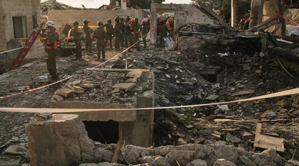 عمال إنقاذ في موقع صاروخ إيراني في بيت شيمش قرب القدس يوم الأحد (أ.ب)