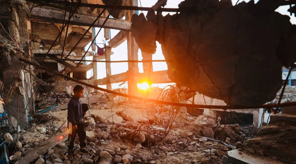 طفل فلسطيني يسير فوق الأنقاض في مخيم البريج بوسط قطاع غزة (أ.ف.ب)