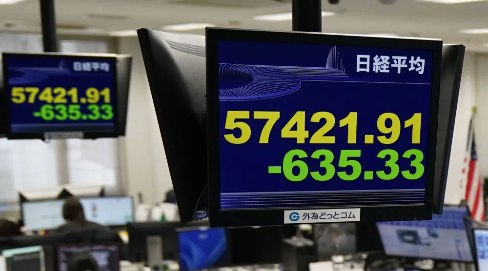 لوحات الأسهم الإلكترونية تعرض مؤشر «نيكي» الياباني في شركة وساطة لصرف العملات الأجنبية (أ.ب)