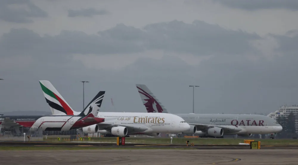 طائرات «طيران الإمارات» و«الخطوط الجوية القطرية» متوقفة على المدرج في مطار «سيدني كينغزفورد سميث» في سيدني (رويترز)
