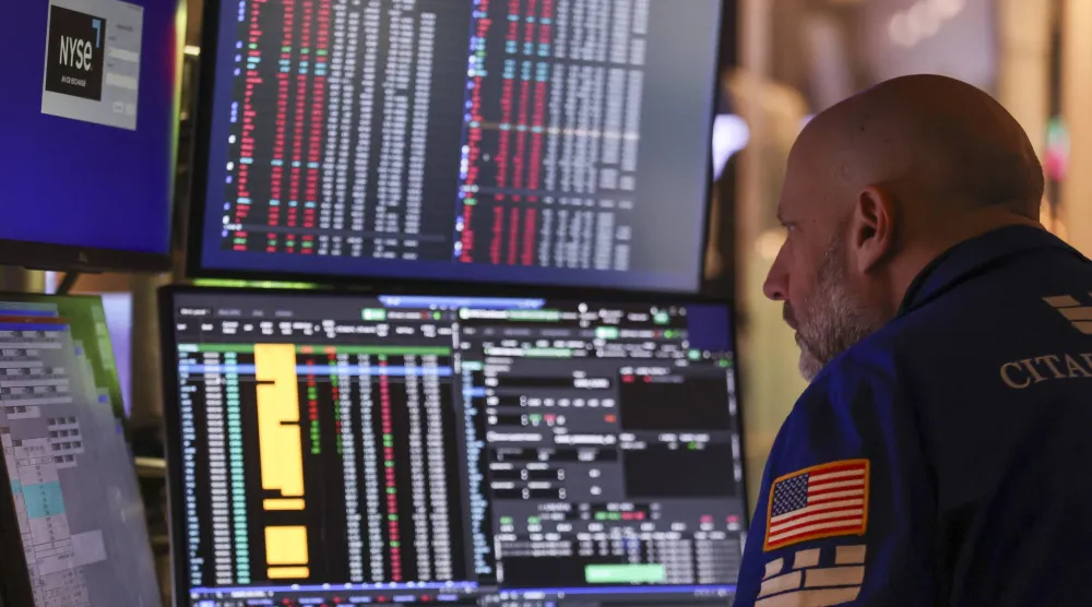 متداول يراقب شاشة تعرض مؤشرات الأسهم في بورصة نيويورك (إ.ب.أ)