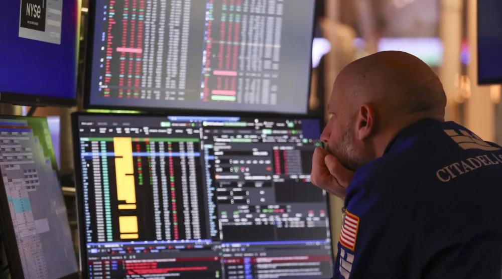 متداول يراقب شاشات تعرض مؤشرات الأسهم في بورصة نيويورك (إ.ب.أ)