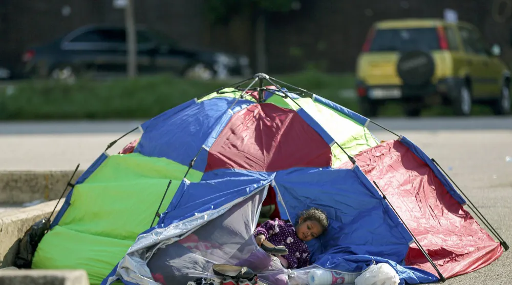 عائلة لبنانية تجلس في خيمة وسط بيروت بعد فرارها من منزلها بالضواحي الجنوبية للمدينة (د.ب.أ)
