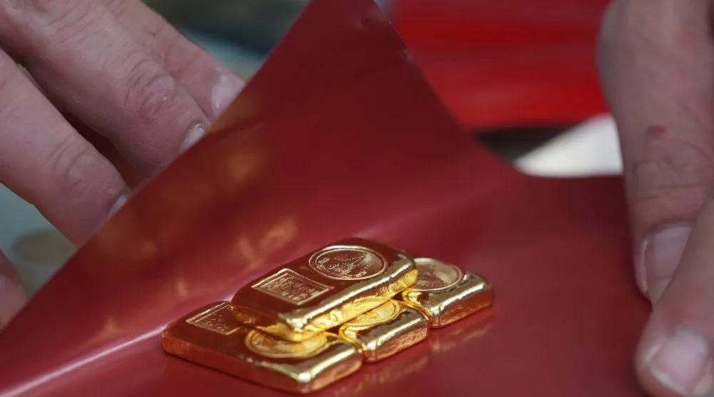 يشتري أحد الزبائن سبائك الذهب في متجر ببانكوك بتايلاند (أ.ب)