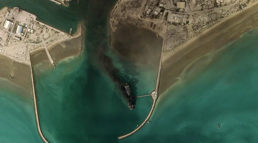 صورة بالأقمار الصناعية تُظهر تصاعد الدخان من سفينة في مضيق هرمز (أ.ف.ب)