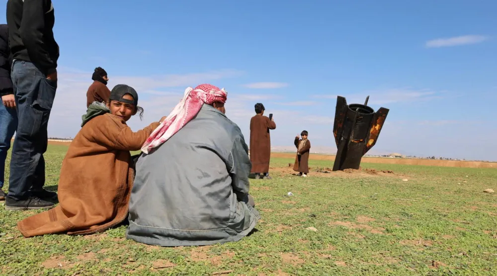 سكان قرية قزلجو بريف القامشلي شمال شرقي سوريا متجمعون عند صاروخ إيراني سقط في قريتهم الأربعاء (إ.ب.أ)