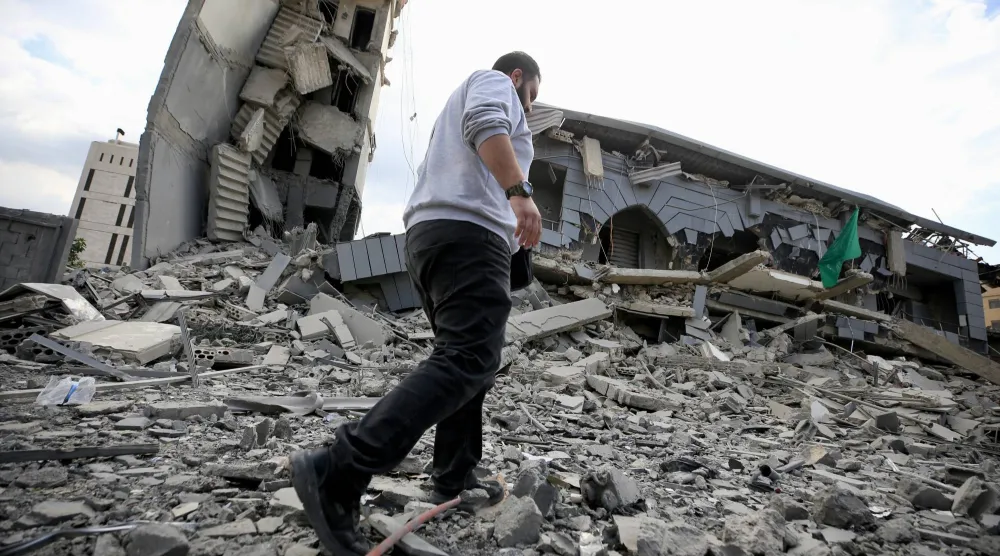 أحد السكان يتفقد ركام مبنى «الجماعة الإسلامية» الذي دمرته إسرائيل في مدينة صيدا الثلاثاء (إ.ب.أ)