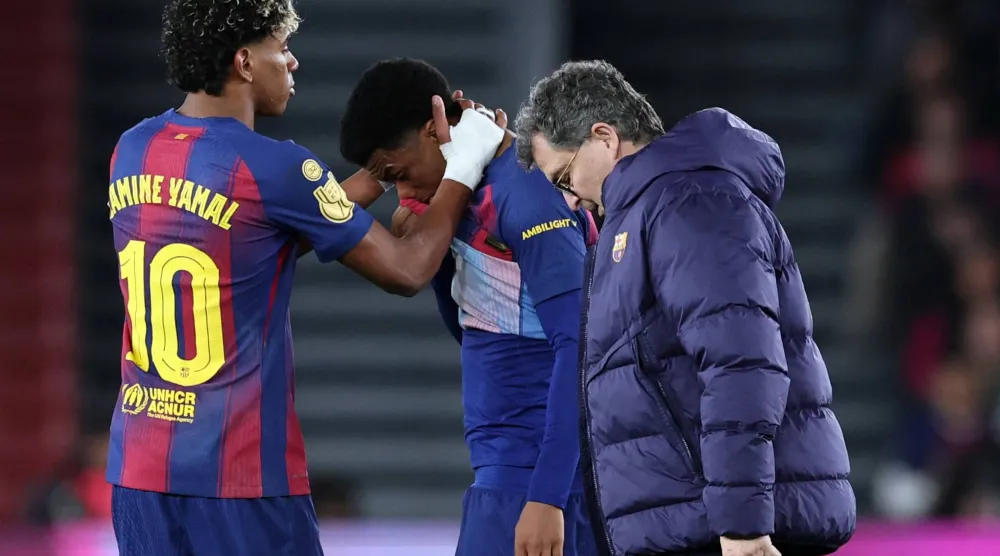 لامين جمال يواسي أليخاندرو بالدي أثناء خروجه من الملعب بعد تعرضه لإصابة خلال مباراة إياب نصف نهائي كأس ملك إسبانيا أمام أتلتيكو مدريد (أ.ف.ب)