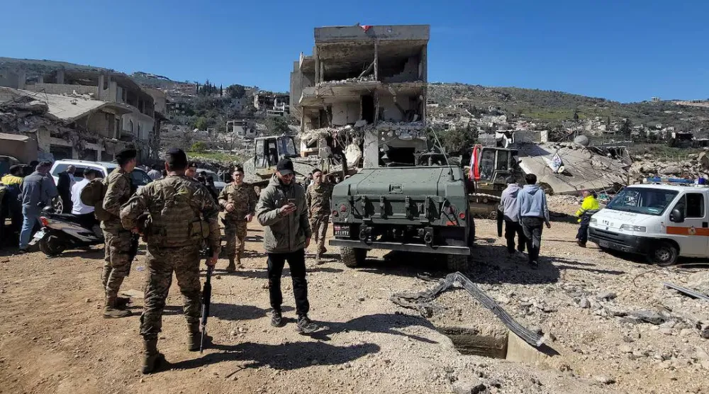 أفراد من الجيش اللبناني وسكان محليون يتفقدون الأضرار في قرية كفركلا بجنوب لبنان يوم 18 فبراير 2025 (رويترز)