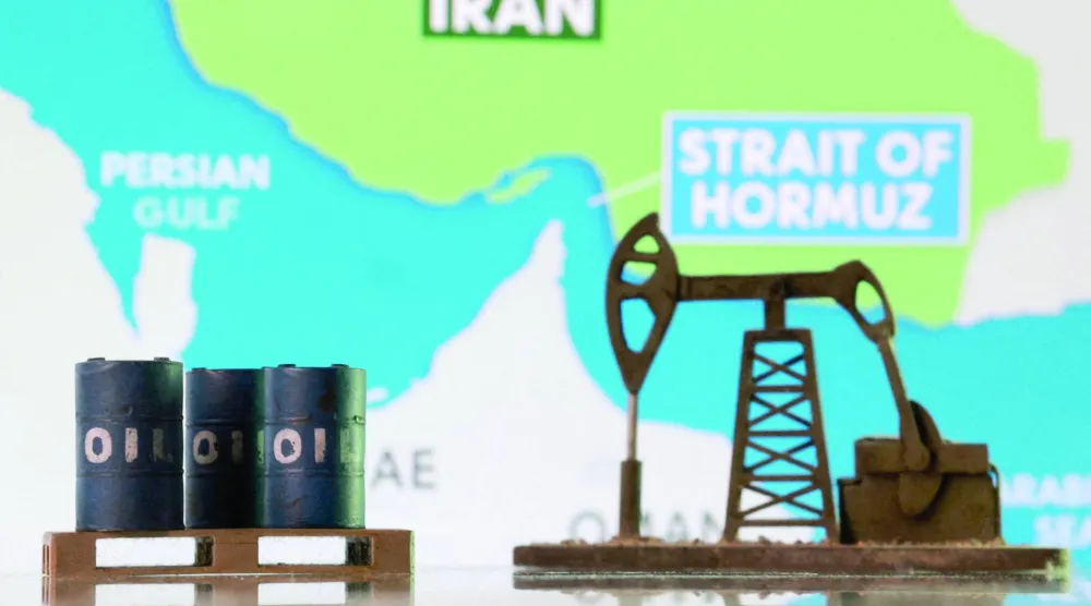 براميل نفط مطبوعة بتقنية الطباعة الثلاثية الأبعاد ومضخة نفط وخريطة توضح مضيق هرمز وإيران (رويترز)