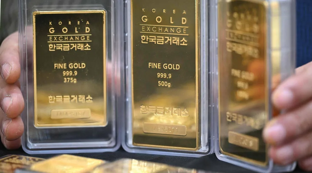 موظف يعرض سبائك ذهبية في متجر بورصة الذهب الكورية في سيول (أ.ف.ب)