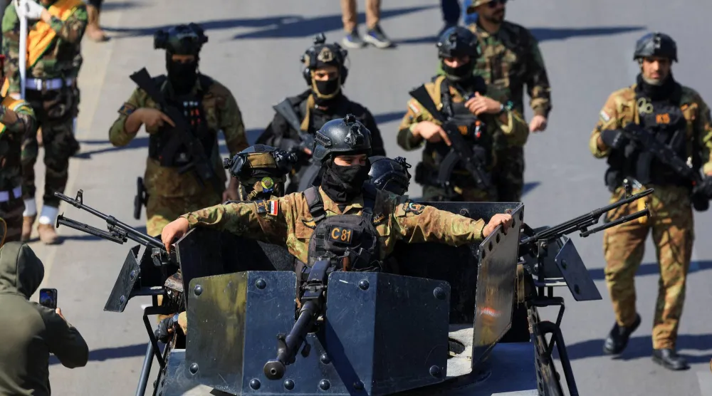 عناصر من كتائب «حزب الله» العراقية يشاركون في جنازة مقاتلين قضوا في الضربات الأخيرة على البلاد (رويترز)