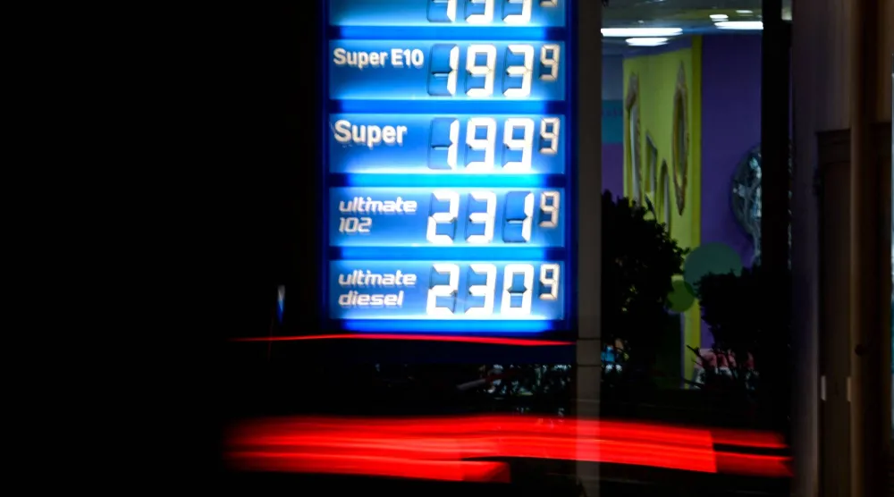 سيارة تمر أمام شاشة مضيئة تعرض أسعار الوقود في محطة بنزين ببرلين (أ.ف.ب)