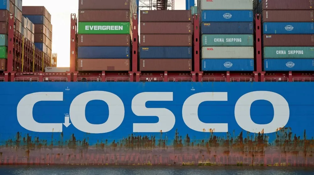 سفينة الشحن التابعة لشركة «كوسكو» في محطة حاويات (رويترز)