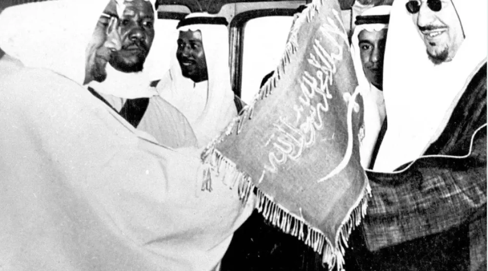 الملك سعود يتسلم العَلَم السعودي في إحدى المناسبات (واس) 