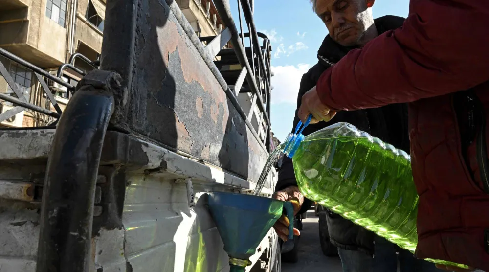 رجل يعبئ سيارته بالوقود في محطة بنزين بدمشق كإجراء احترازي وسط الحرب الدائرة في الشرق الأوسط (إ.ف.ب)