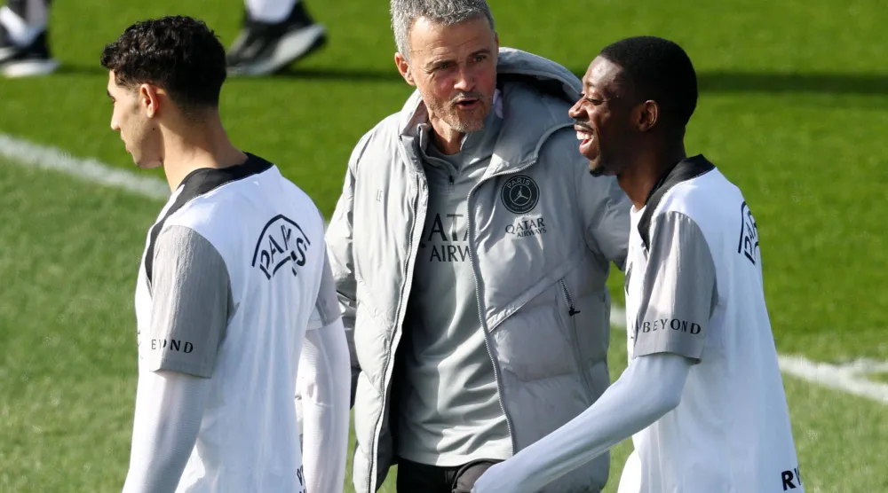 إنريكي يتحدث إلى ديمبلي خلال التدريبات الأخيرة (أ.ف.ب)