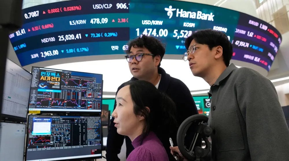 متعاملو العملات يراقبون مؤشر «كوسبي» وسعر الدولار مقابل الوون في بنك هانا بسيول (أ.ب)