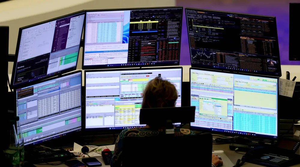 وسيط يراقب نشاط الأسهم بمكتبه في بورصة فرانكفورت (إ.ب.أ)