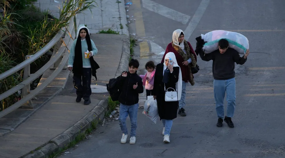 نازحون من الجنوب يحملون أمتعتهم لدى وصولهم إلى مدينة صيدا (أ.ب)