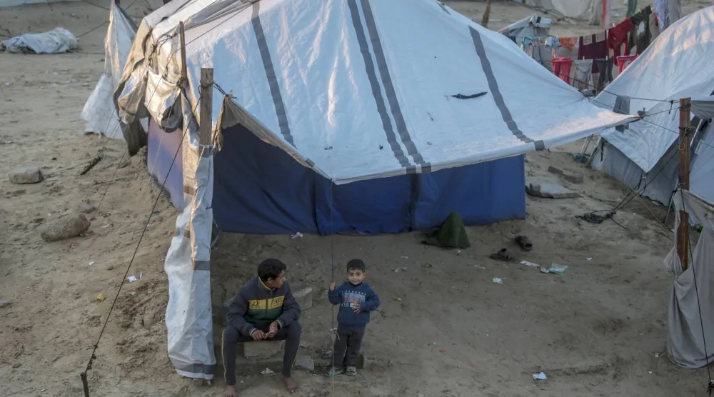 أطفال فلسطينيون نازحون أمام خيام في مدينة غزة (إ.ب.أ)