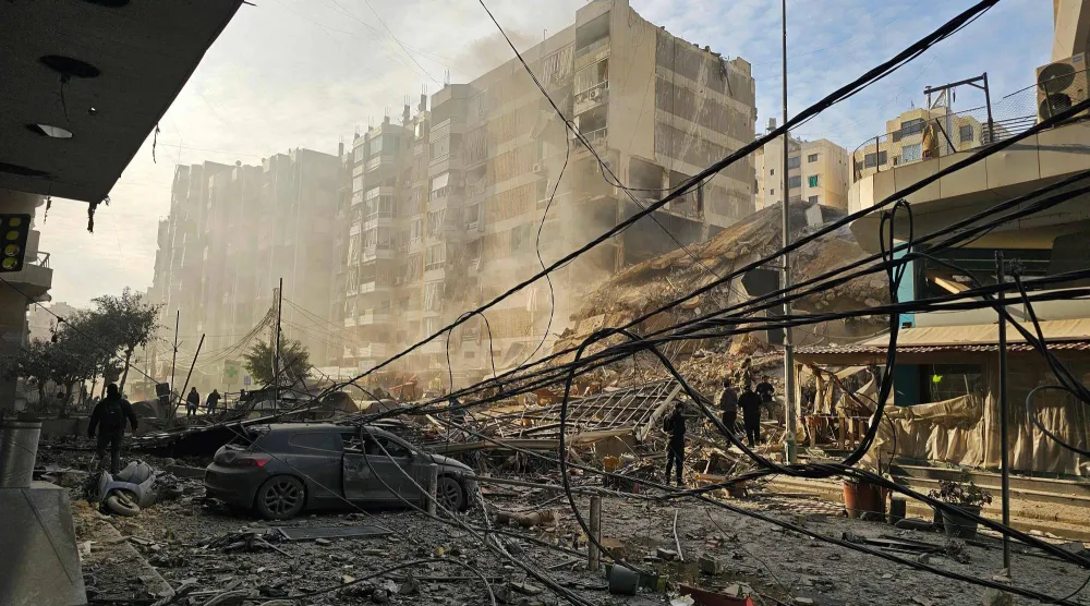 سكان محليون يتفقدون الأضرار الناتجة عن غارات إسرائيلية استهدفت منطقة مار مخايل على مدخل الضاحية الجنوبية لبيروت (أ.ف.ب)