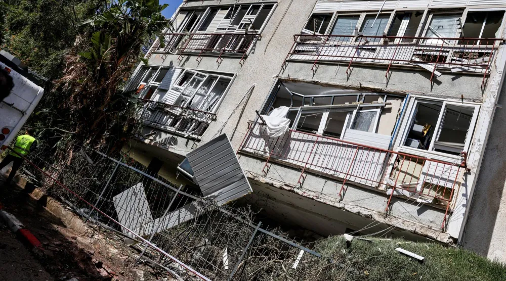 مبنى متضرر من القصف بإحدى ضواحي تل أبيب (رويترز)