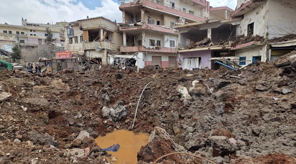 حفرة كبيرة وسط بلدة النبي شيت نتيجة عشرات الغارات الإسرائيلية التي استهدفت البلدة (أ.ب)