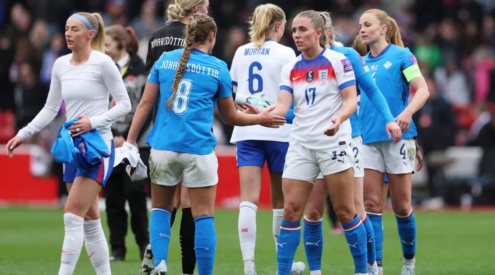 سيدات إنجلترا يصافحن نظيراتهن الآيسلنديات بعد مباراة تصفيات المونديال (رويترز)