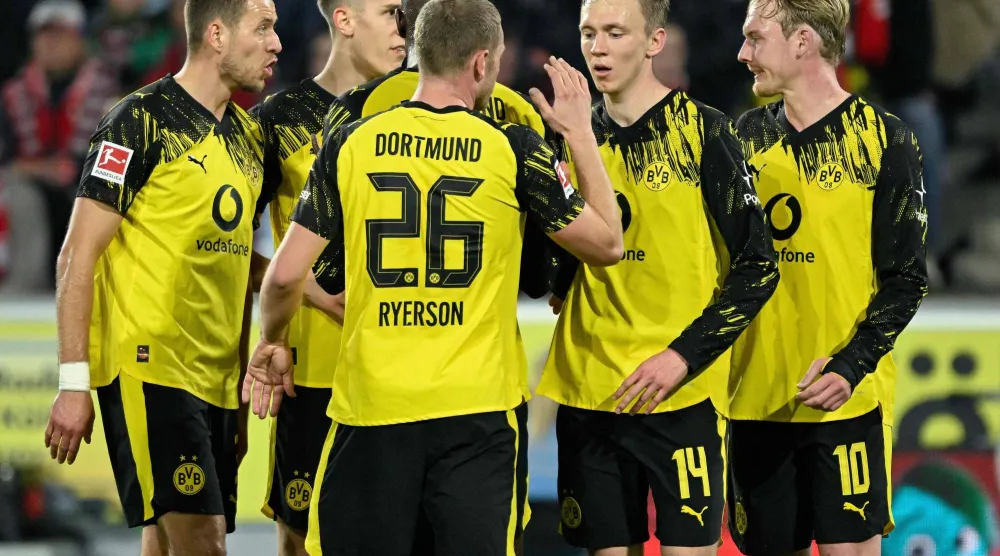 لاعبو دورتموند يحتفلون بالهدف الأول في المباراة (أ.ف.ب)