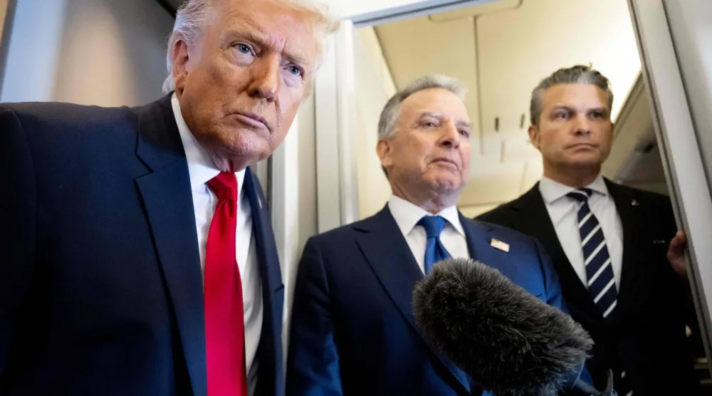 الرئيس الأميركي دونالد ترمب يتحدث إلى وسائل الإعلام وخلفه وزير الدفاع بيت هيغسيث (يمين) والمبعوث الخاص ستيف ويتكوف (وسط) على متن طائرة الرئاسة «إير فورس ون» خلال رحلة من دوفر (أ.ف.ب)