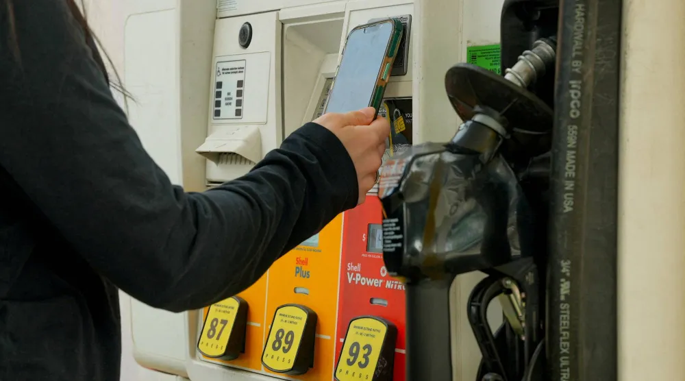 امرأة تدفع ثمن البنزين في محطة «شل» بواشنطن العاصمة (رويترز)